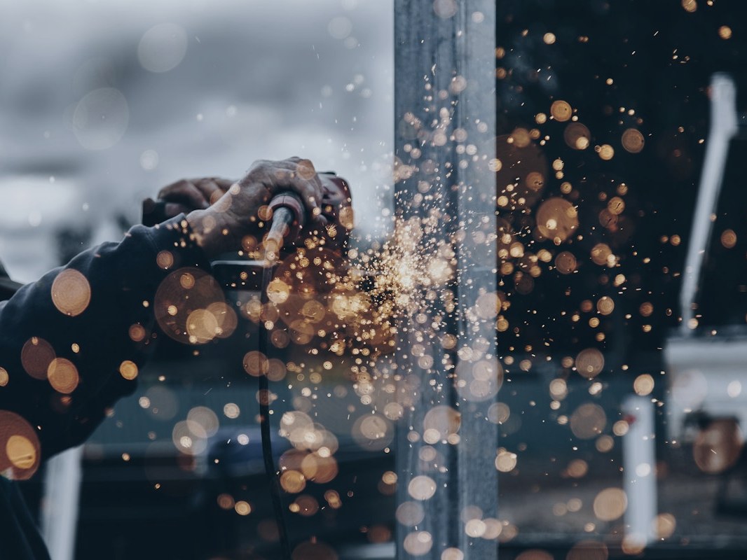 Technician grinding steel during heavy industrial maintenance work